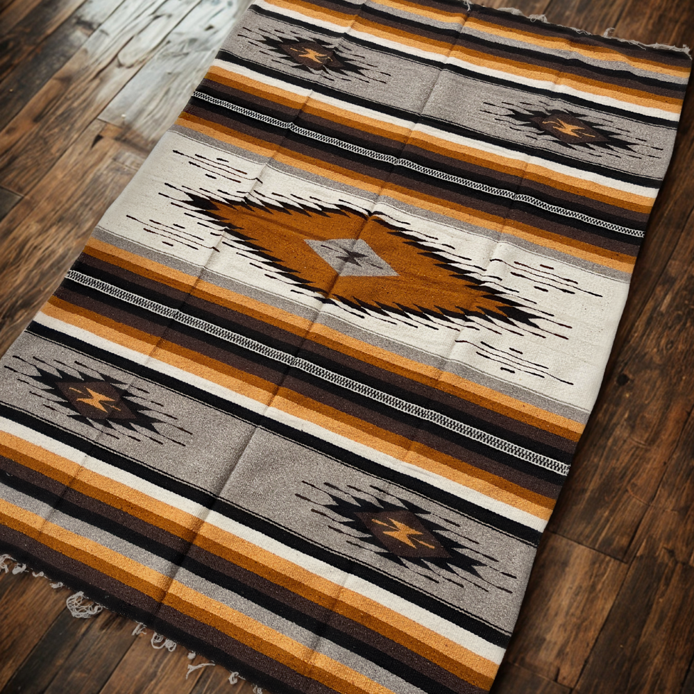 Patterned rug with brown, black, and beige colors on a wooden floor.