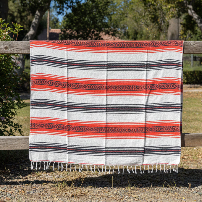 Striped blanket with red, white, and black pattern on a road