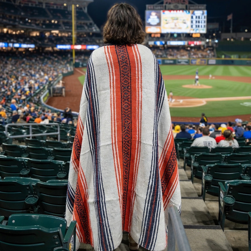 Person wearing a colorful poncho at a baseball stadium
