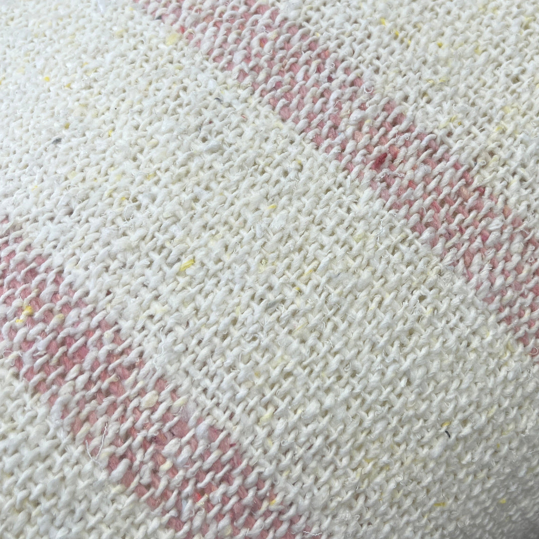Close-up of a textured white fabric with red patterns on a blurred background