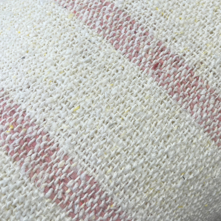 Close-up of a textured white fabric with red patterns on a blurred background
