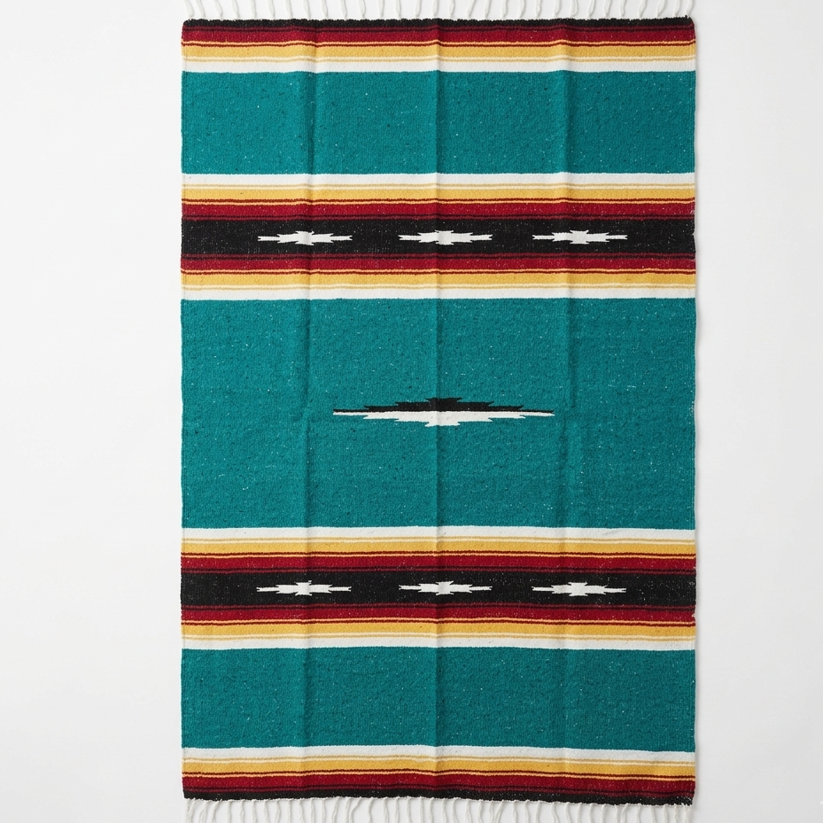 Colorful woven blanket with a geometric pattern on a white background