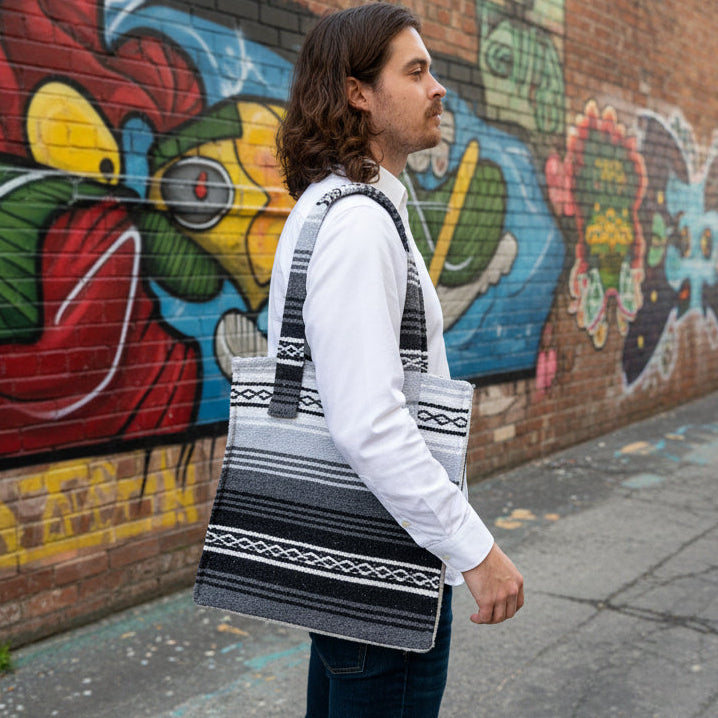 Person standing in front of a colorful mural on a brick wall