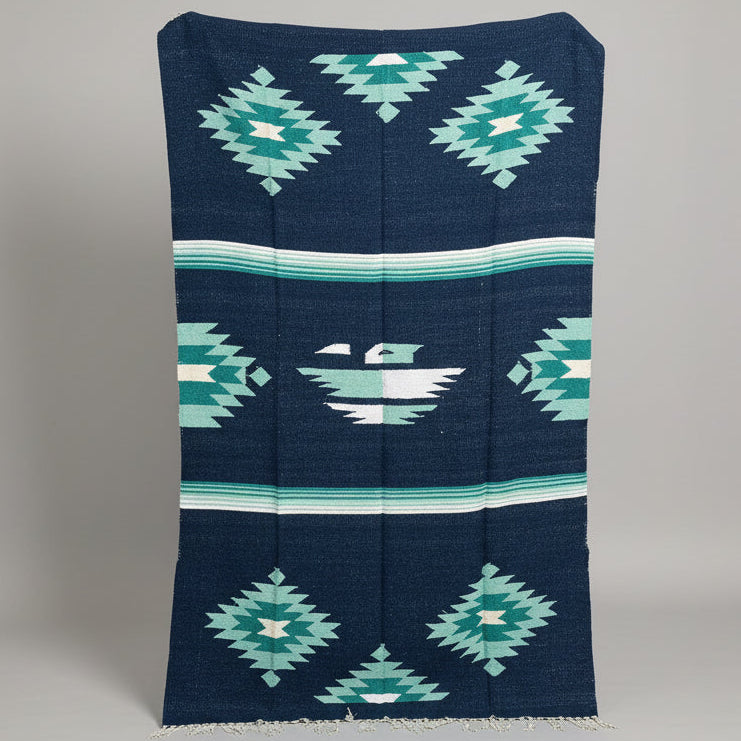 Navy blue fabric with green geometric patterns on a gray background