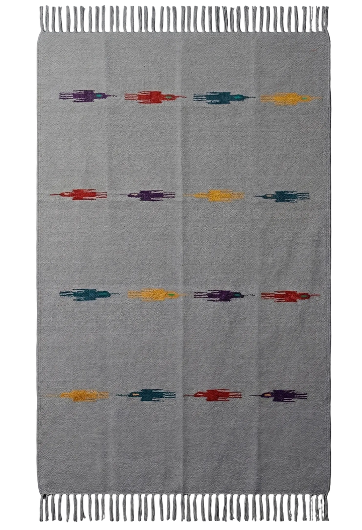 Gray blanket with colorful geometric patterns on a gray background