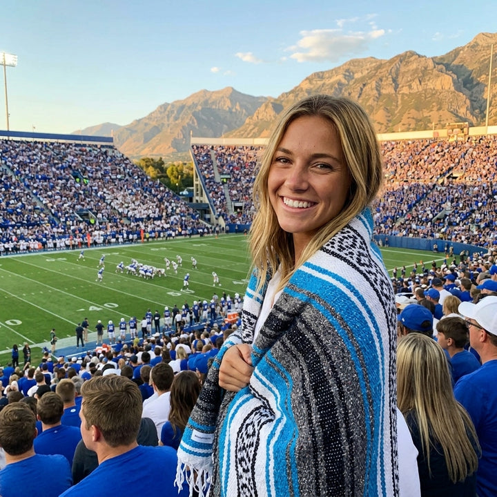 Fan wrapped in a Mexican stadium blanket in Brigham Young University colors at a college football game