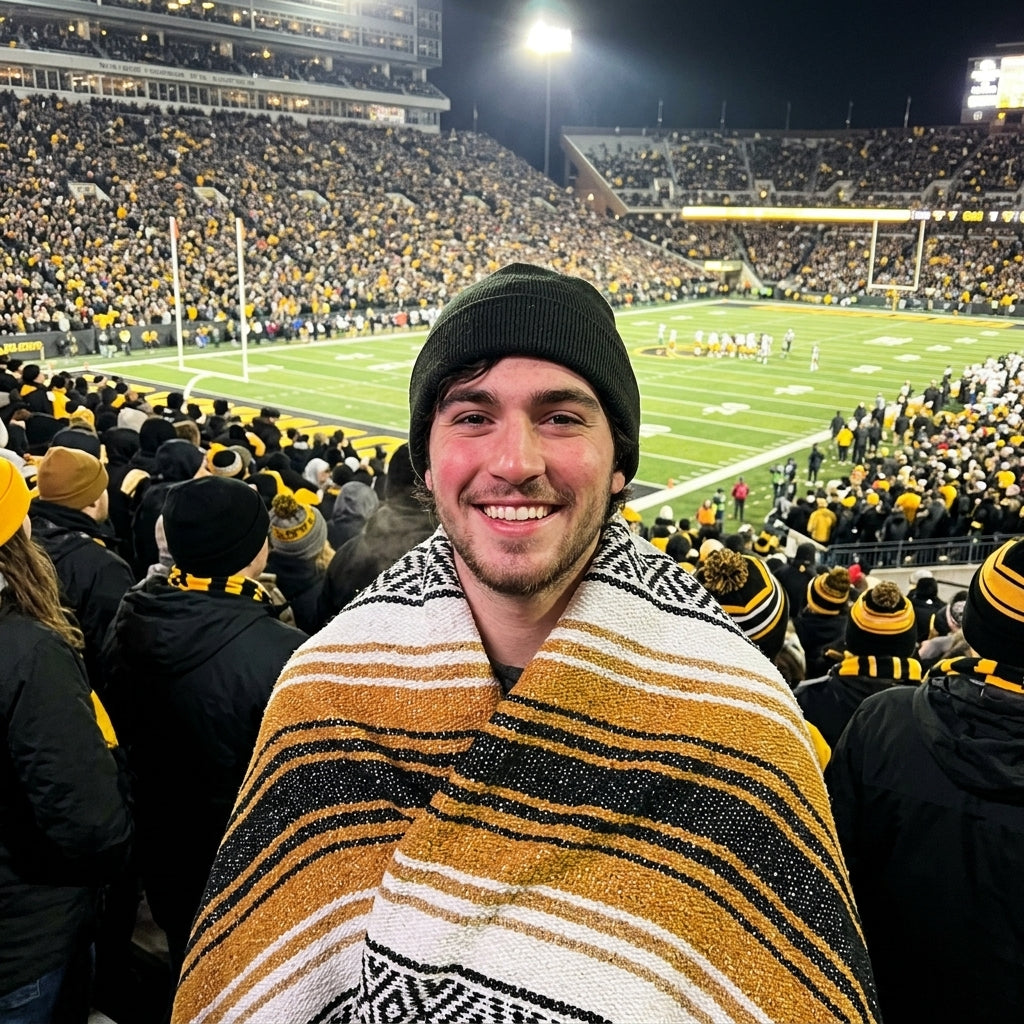 Fan wrapped in a Mexican stadium blanket in University of Iowa colors at a college football game