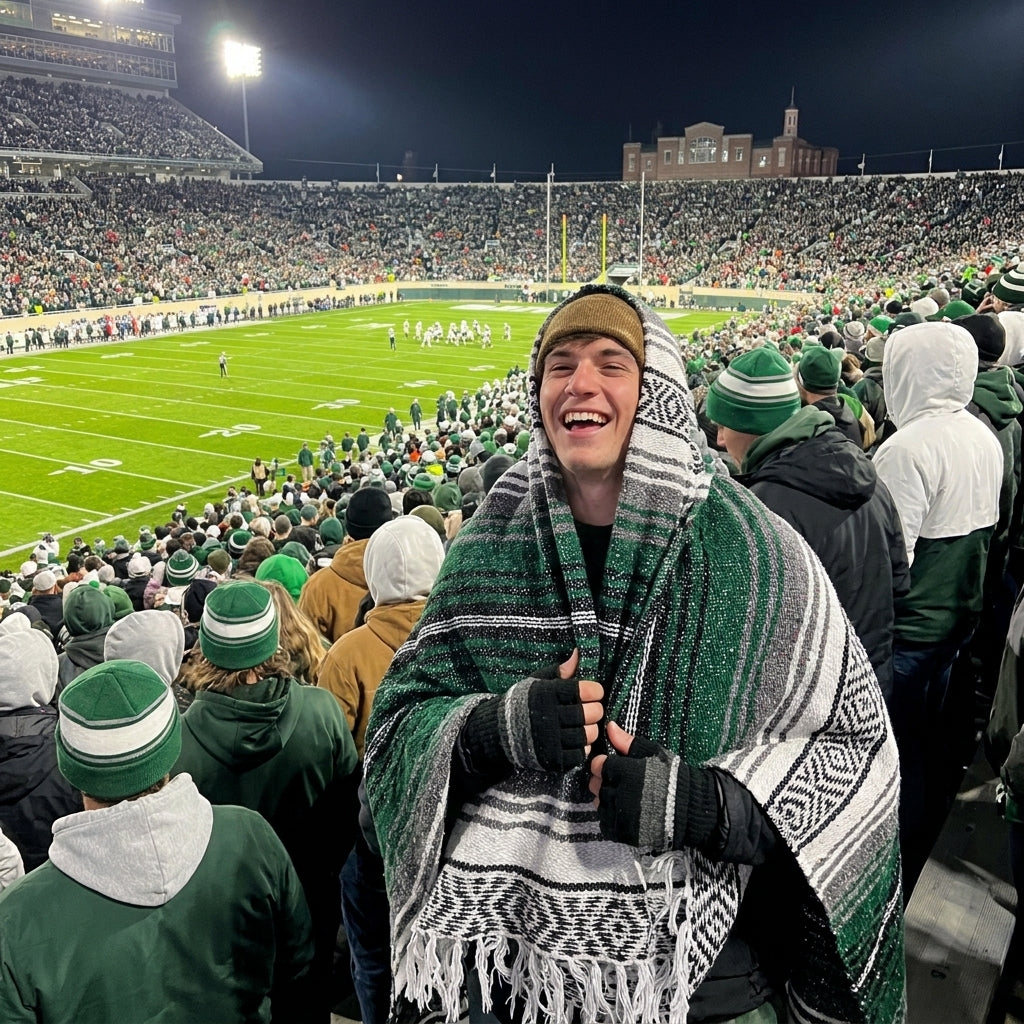 Fan wrapped in a Mexican stadium blanket in Michigan State University colors at a college football game