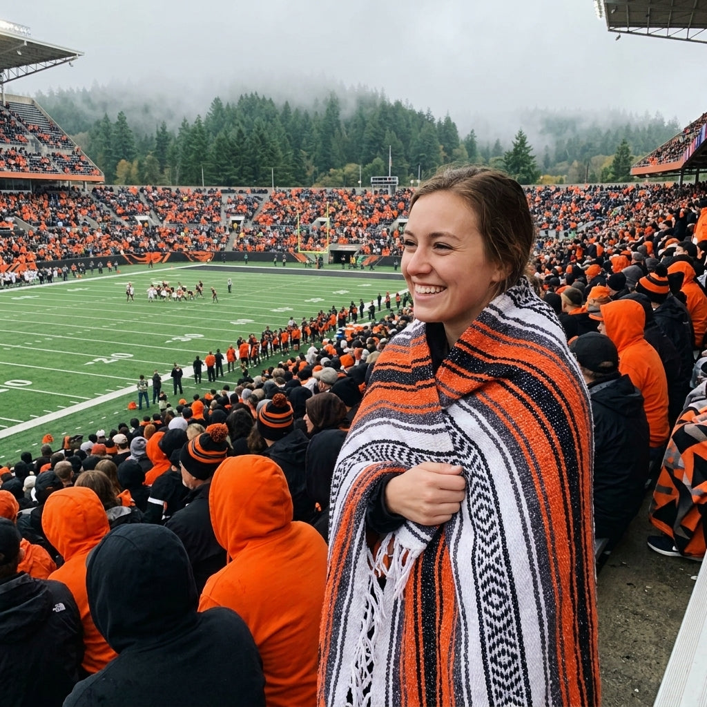 Fan wrapped in a Mexican stadium blanket in Oregon State University colors at a college football game