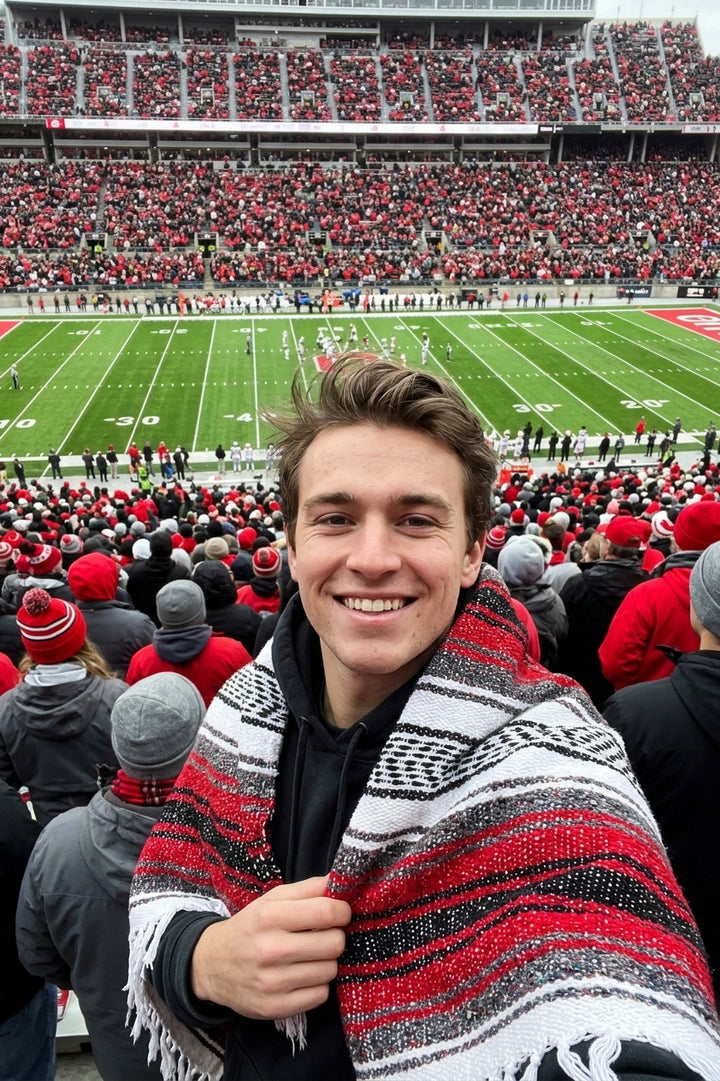 Fan wrapped in a Mexican stadium blanket in Ohio State University colors at a college football game