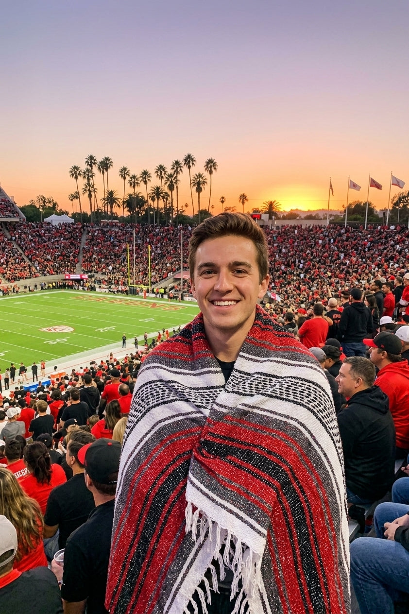 Fan wrapped in a Mexican stadium blanket in San Diego State University colors at a college football game