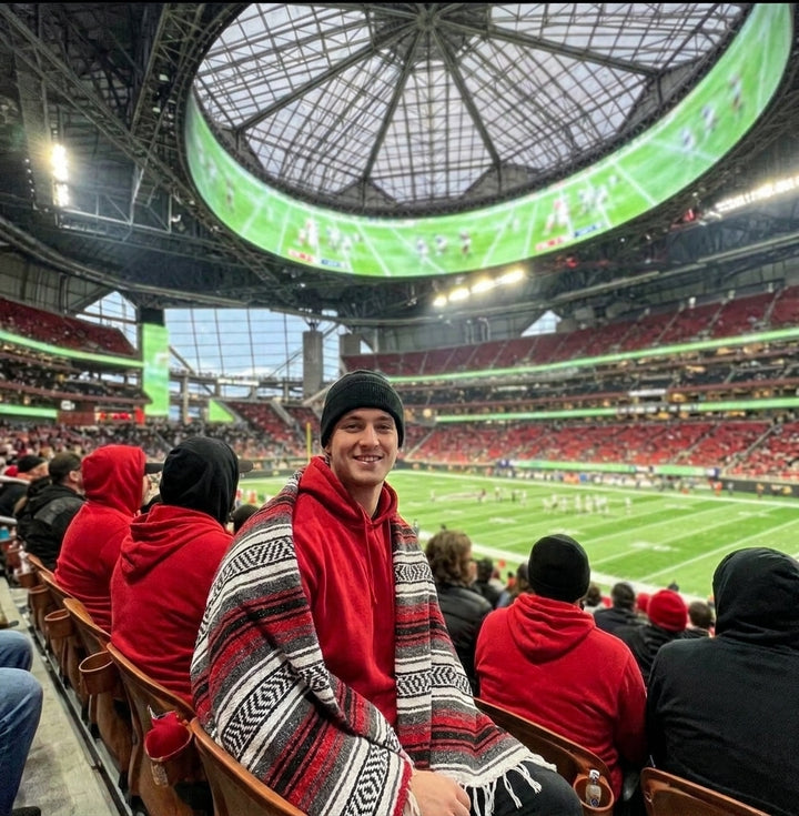 Fan wrapped in a Mexican stadium blanket at an Atlanta football game