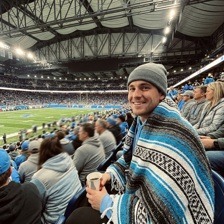 Fan wrapped in a Mexican stadium blanket at a Detroit football game