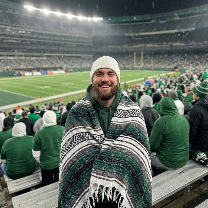 Fan wrapped in a Mexican stadium blanket at a New York football game